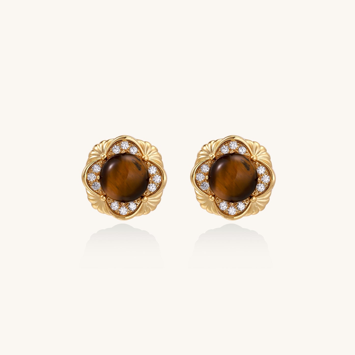 Ornate gold-plated brass stud earrings featuring round tiger's eye stones surrounded by sparkling zirconia in floral design