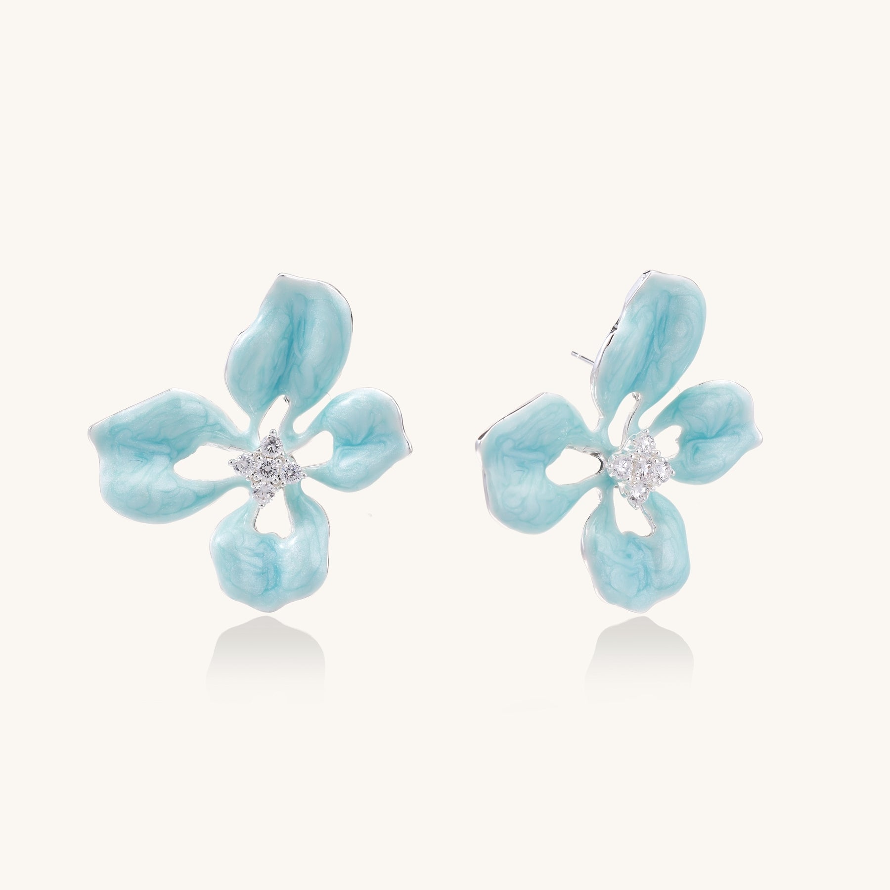 Turquoise blue enamel flower earrings with crystal centers and gold-plated brass posts on white background.