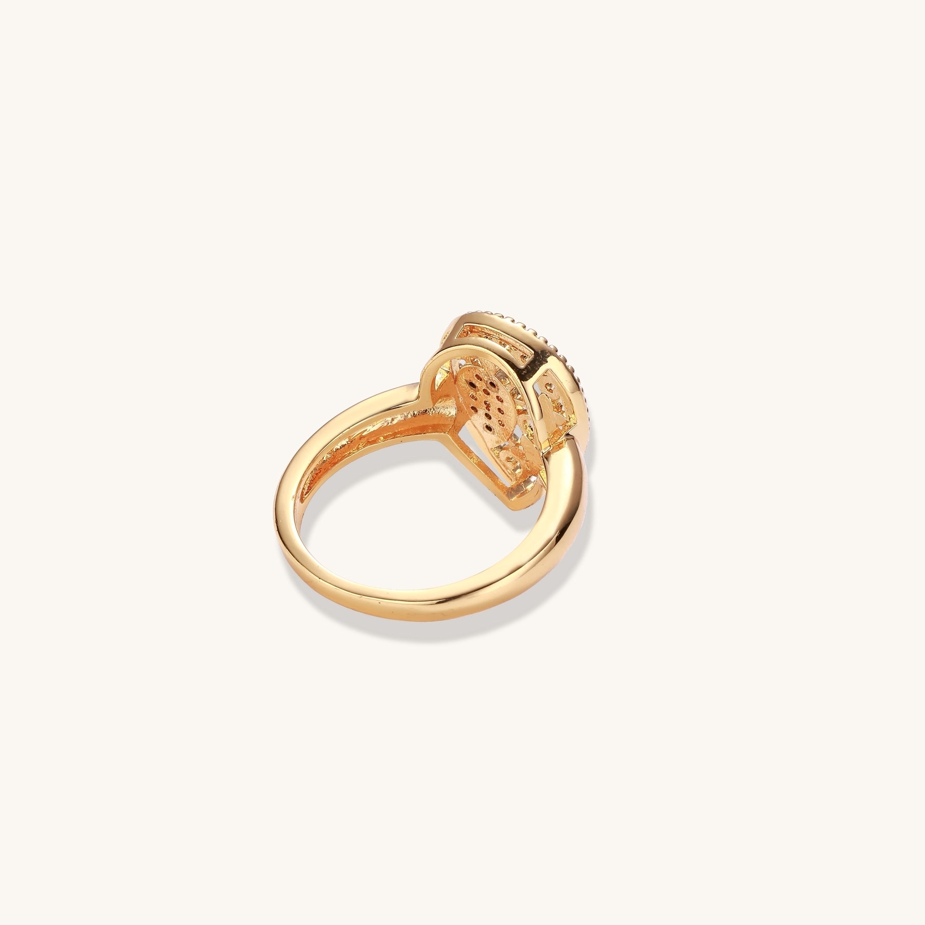 Gold-plated heart ring with turquoise enamel scrollwork and cubic zirconia stones on white background