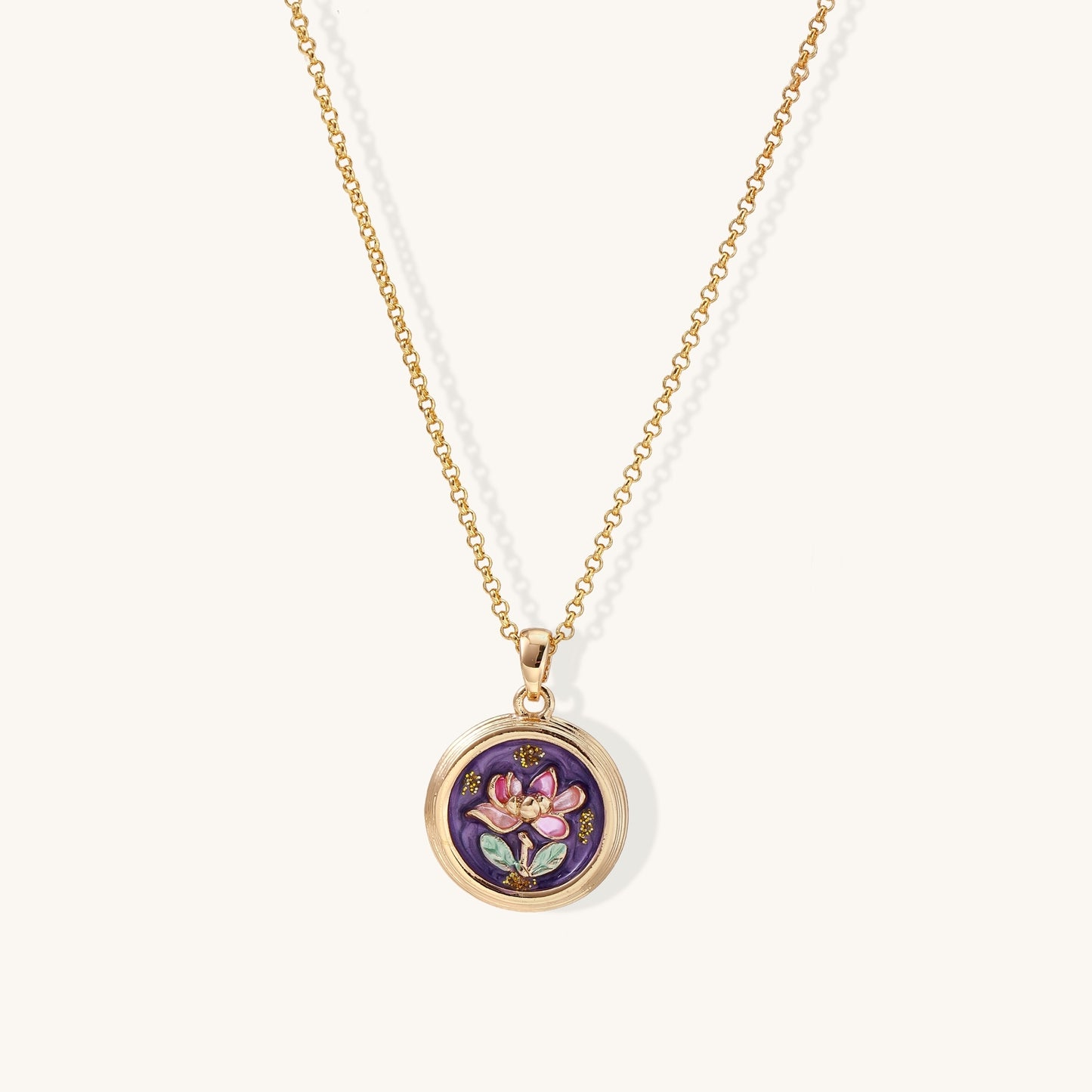 Gold-plated necklace with purple enamel pendant featuring pink floral design on white background