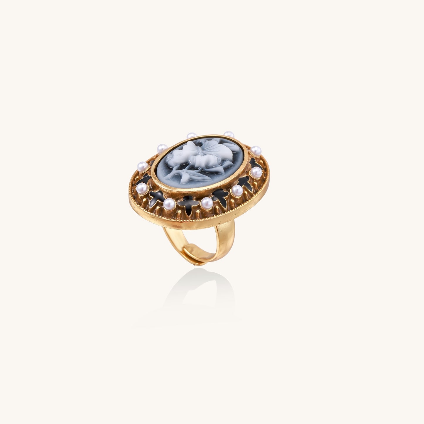 Oval cameo ring with blue-grey floral design surrounded by white shell pearls in gold-plated brass setting