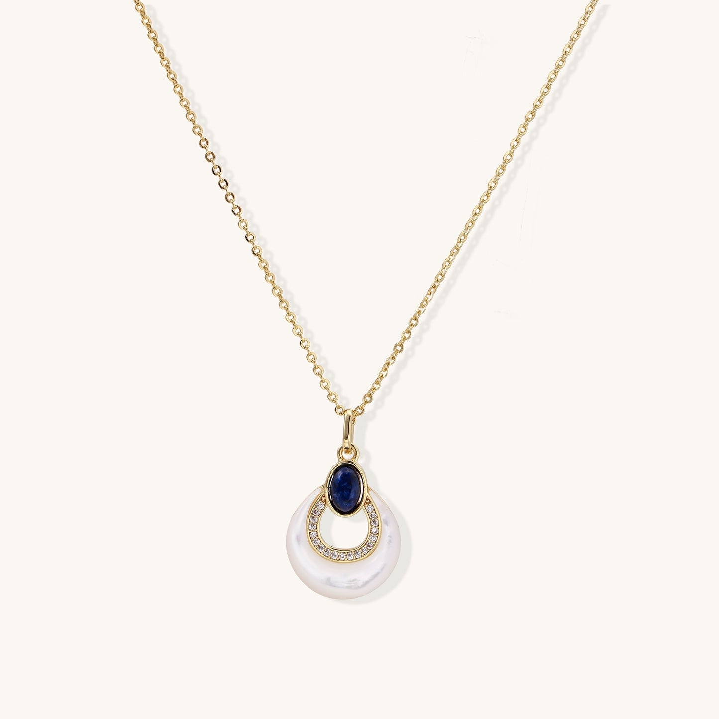 Layered pendant necklace with deep blue lapis lazuli stone, crystals, and white mother of pearl on 18k gold plated chain
