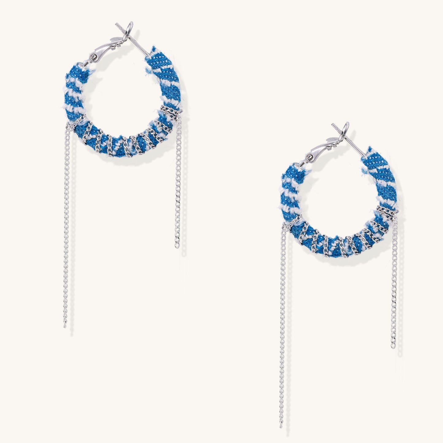 Blue and white checkered denim-wrapped hoop earrings with delicate silver chain dangles on neutral background