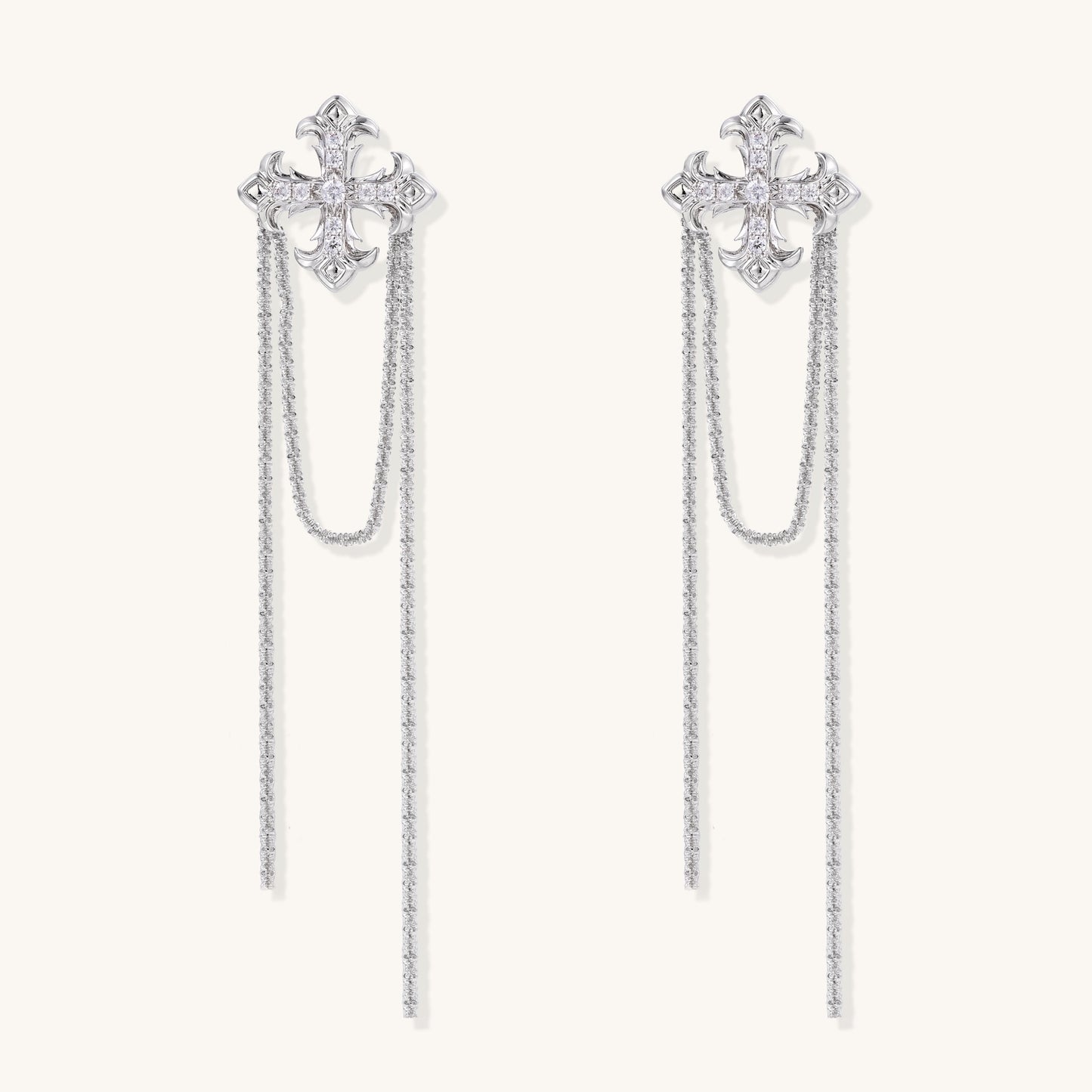 Ornate gold-plated cross earrings with zirconia crystals and flowing chain details on white background