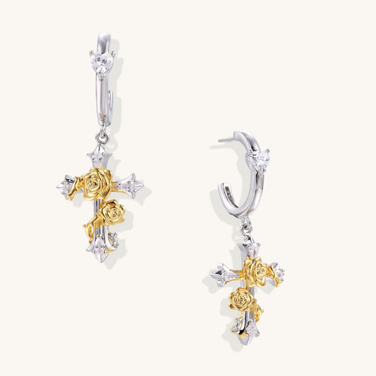Ornate cross-shaped dangle earrings with gold roses and sparkling zirconia stars on silver-toned base with hoop closures.