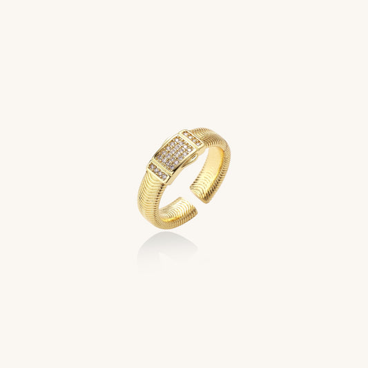 Gold-plated brass cuff ring with textured band and rectangular cubic zirconia centerpiece on cream background