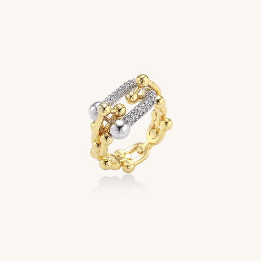 Bold gold-plated chain-link ring with cubic zirconia bars and sphere details on white background.