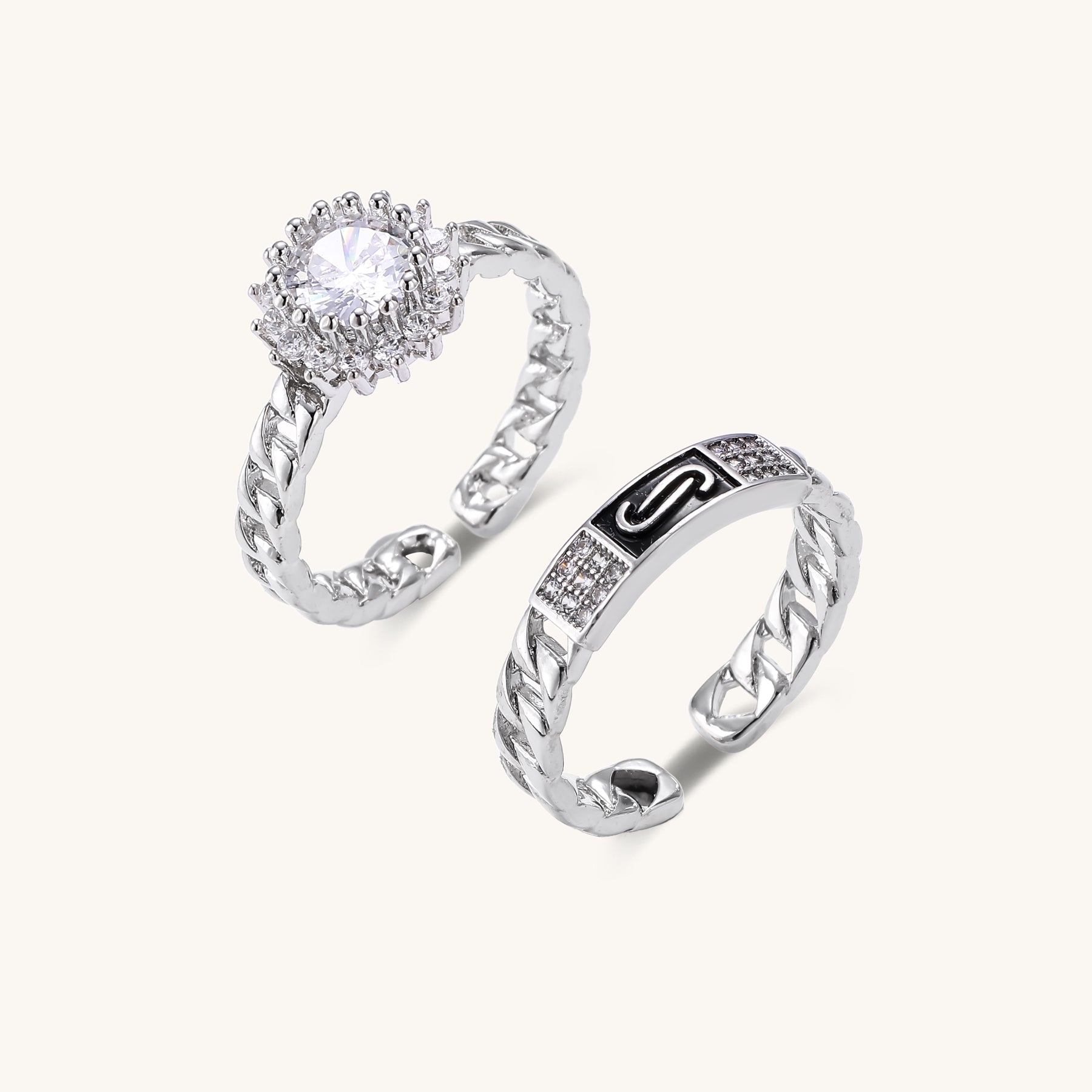 Two gold-plated rings with chain-link bands, one featuring cubic zirconia halo setting, displayed on neutral background