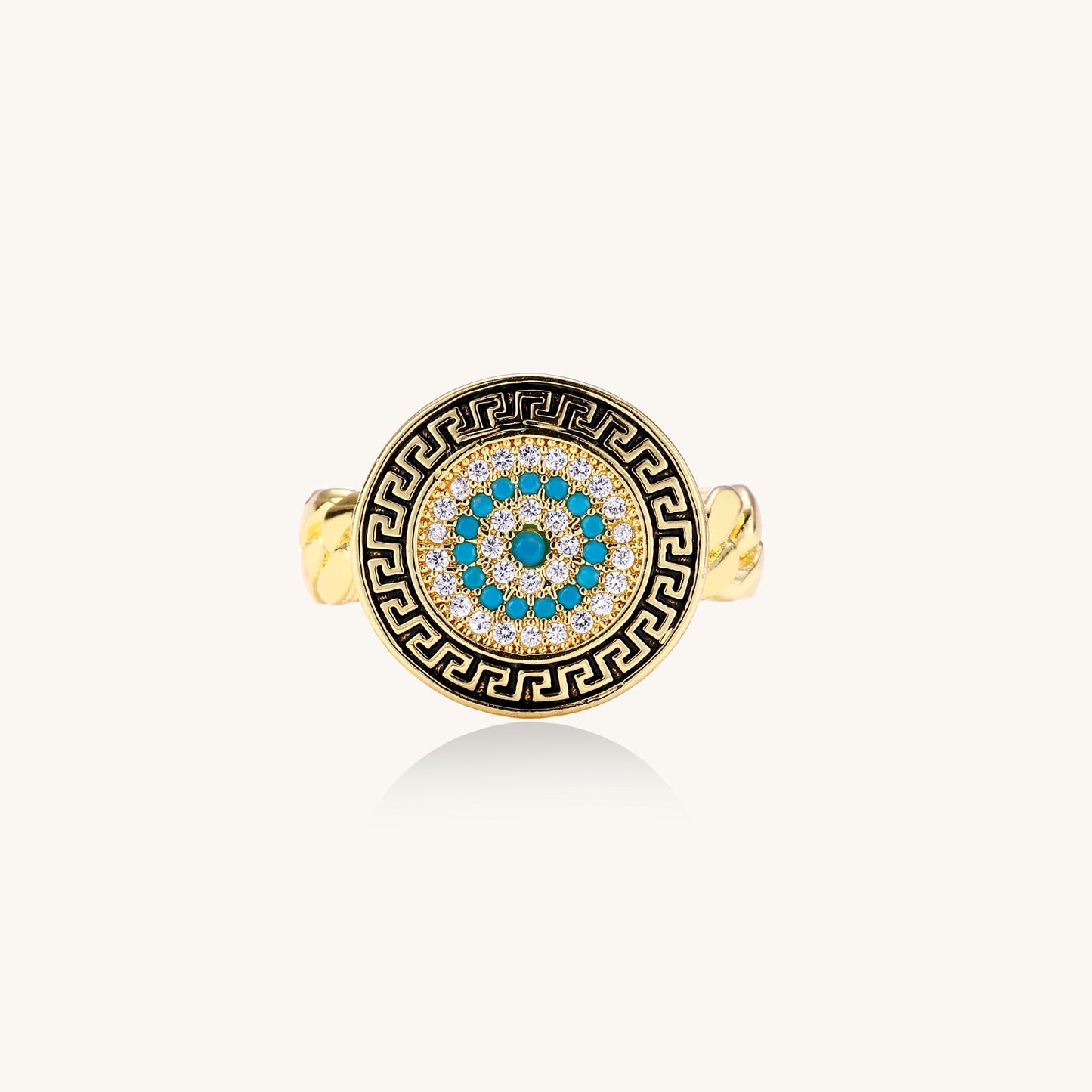 Gold-plated brass ring with Greek key border, evil eye center, and turquoise cubic zirconia stones in chunky chain band style.