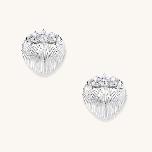 Pair of gold-plated heart-shaped earrings with vertical ribbed texture and sparkling zirconia stones at top on white background.