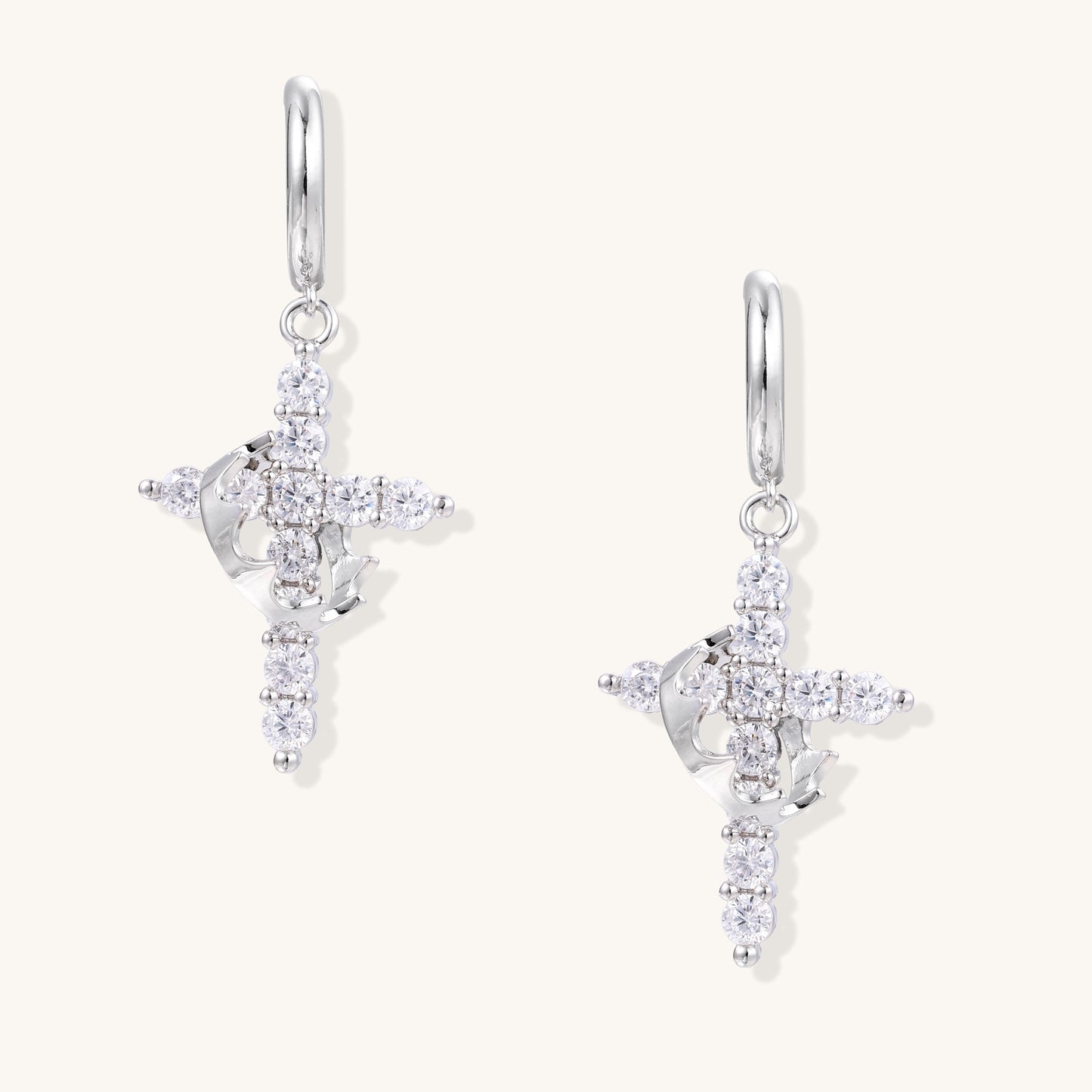 Ornate cross dangle earrings with zirconia stones and gold-plated brass construction on white background.