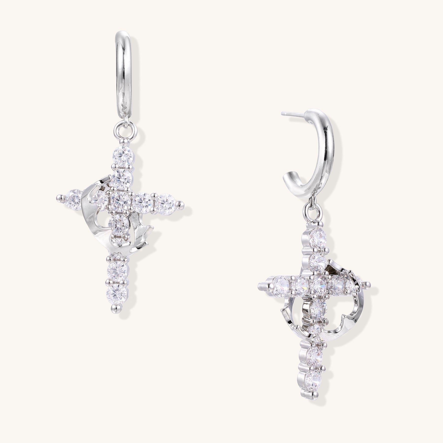 Ornate cross dangle earrings with zirconia stones and gold-plated brass construction on white background.