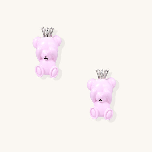 Pair of pink teddy bear-shaped stud earrings with silver crowns on white background, made from gold-plated brass