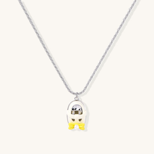 Minimalist gold plated brass necklace with cute capsule pendant featuring yellow bow detail on neutral background.