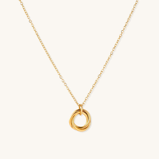 Close-up of a gold-plated stainless steel necklace with interlocking twisted ring pendant on white background