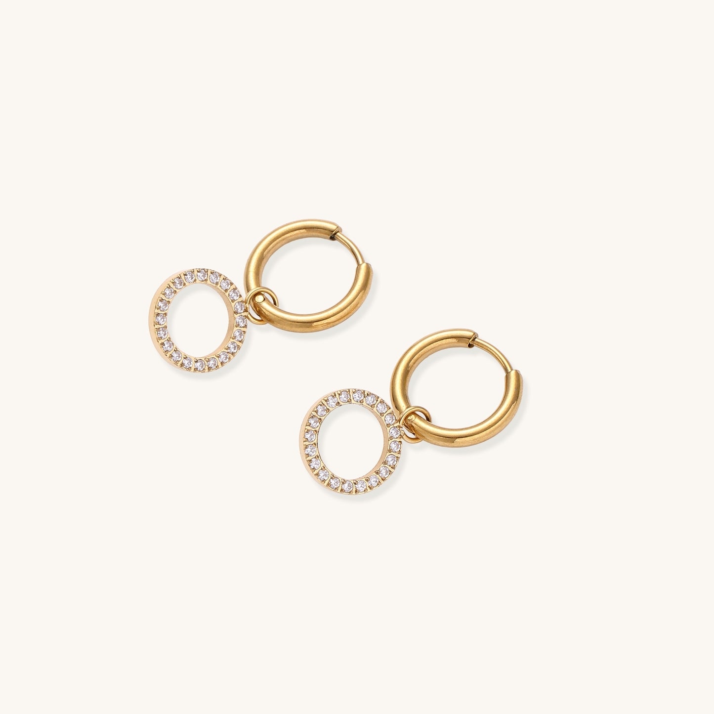 Gold-plated hoop earrings with circular cubic zirconia charm dangles displayed on neutral background.